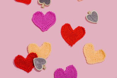 El yapımı sevgililer günü konsepti. Yaratıcı örgü kalpler, bahar işçiliği. Kutlama kartı, pembe arka plan, sert ışık, koyu gölge, düz yer, üst manzara.