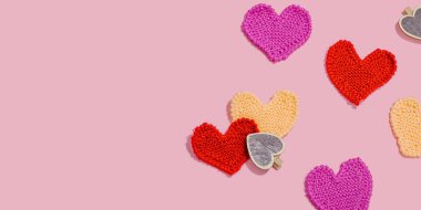 El yapımı sevgililer günü konsepti. Yaratıcı örgü kalpler, bahar işçiliği. Kutlama kartı, pembe arka plan, sert ışık, koyu gölge, düz yatış, pankart biçimi