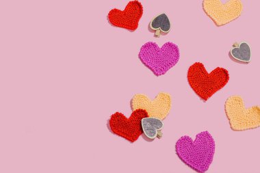 El yapımı sevgililer günü konsepti. Yaratıcı örgü kalpler, bahar işçiliği. Kutlama kartı, pembe arka plan, sert ışık, koyu gölge, düz yer, üst manzara.