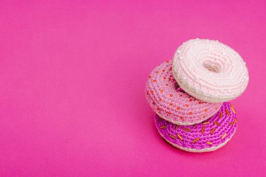 Parlak boncuklu el yapımı örülü çörekler. Sevgililer Günü ya da Anneler Günü, tebrik kartı, yaratıcı sanatlar konsepti. Magenta arkaplanı, kopyalama alanı
