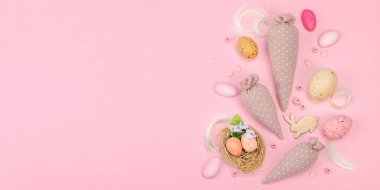 El yapımı Paskalya konsepti. Geleneksel dekorasyonlu tekstil havuçları dikmek. Kutlama sembolleri, tebrik kartları, düz yatış. Yaratıcı zanaat kavramı, pastel pembe arkaplan, afiş biçimi