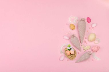 El yapımı Paskalya konsepti. Geleneksel dekorasyonlu tekstil havuçları dikmek. Kutlama sembolleri, tebrik kartları, düz yatış. Yaratıcı zanaat konsepti, pastel pembe arkaplan, üst görünüm