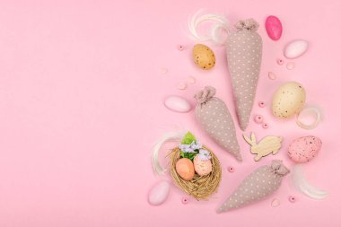 El yapımı Paskalya konsepti. Geleneksel dekorasyonlu tekstil havuçları dikmek. Kutlama sembolleri, tebrik kartları, düz yatış. Yaratıcı zanaat konsepti, pastel pembe arkaplan, üst görünüm
