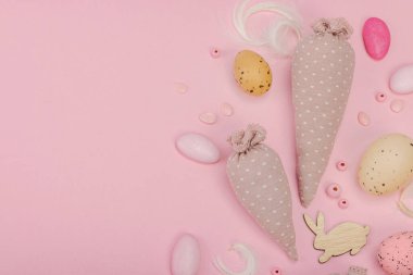 El yapımı Paskalya konsepti. Geleneksel dekorasyonlu tekstil havuçları dikmek. Kutlama sembolleri, tebrik kartları, düz yatış. Yaratıcı zanaat konsepti, pastel pembe arkaplan, üst görünüm