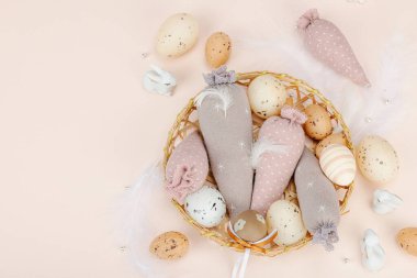 El yapımı Paskalya konsepti. Geleneksel dekorasyonlu tekstil havuçları dikmek. Kutlama sembolleri, tebrik kartları, düz yatış. Yaratıcı zanaat konsepti, kayısı arka planı, üst görünüm