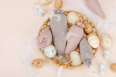 El yapımı Paskalya konsepti. Geleneksel dekorasyonlu tekstil havuçları dikmek. Kutlama sembolleri, tebrik kartları, düz yatış. Yaratıcı zanaat konsepti, kayısı arka planı, üst görünüm