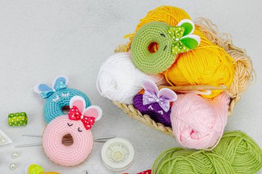 Örgü örmek için bir demet iplik. Tığ işi çörekler, kurdeleler, el yapımı, Paskalya hobisi. Işık taşı arkaplan, üst görünüm üzerine dekorlar ve özel sanatlar araçları