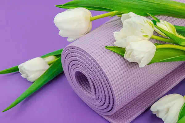 瑜伽时间的概念 传统瑜伽垫 块和贴纸 健康的生活方式 运动锻炼 紫色背景 白色郁金香 平坦平整 — 图库照片