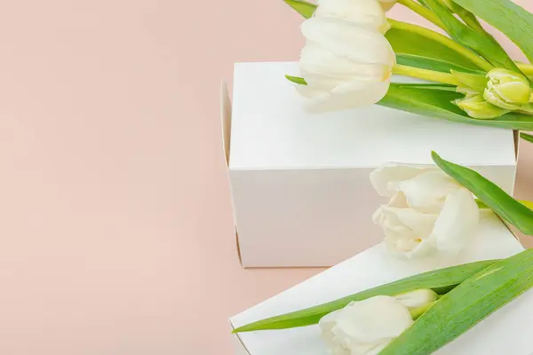 Концепция Подарков Завернутая Коробка Сюрпризов Белые Тюльпаны Фоне Абрикоса Днем — стоковое фото