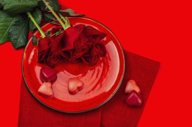 Çikolata şekerli minimalist bahar sofrası. Geleneksel bayram sembolü, tebrik kartı, düz yatak. Tutku kırmızı arkaplan, üst görünüm
