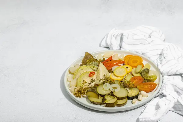 Assorted fermented vegetables. Probiotics, healthy food, vitamins. Vegan lifestyle, pickled dish. Flat lay, light stone concrete background. Hard light, dark shadow, copy space