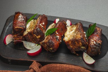 Baharatlı, sebzeli ve soslu domuz pirzolası. Mangal partisi için geleneksel malzeme, piknik konsepti. Jöleli et, keten peçete, son moda tabaklar. Siyah taş arkaplan, kapat