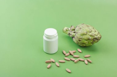 Beslenme takviyeleri enginar yaprağı özü kapsülleri. Alternatif tıp, bitkisel yaşam tarzı, sağlıklı kişisel bakım. Savannah yeşil trend arkaplan, düz yatış, kopyalama alanı