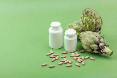 Beslenme takviyeleri enginar yaprağı özü kapsülleri. Alternatif tıp, bitkisel yaşam tarzı, sağlıklı kişisel bakım. Savannah yeşil trend arkaplan, düz yatış, kopyalama alanı