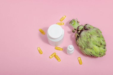 Beslenme takviyeleri enginar yaprağı özü kapsülleri. Alternatif tıp, güzellik bitkisel yaşam tarzı, sağlıklı kişisel bakım. Sert ışık, koyu gölge, pembe arkaplan, düz yatış, üst manzara