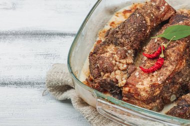 Baharatlı domuz pirzolası, soğuk yağ. Mangal partisi için geleneksel malzeme, piknik konsepti. Keten peçeteli kompozisyon, kırsal tarzda. Beyaz tahta arkaplan, boşluğu kopyala