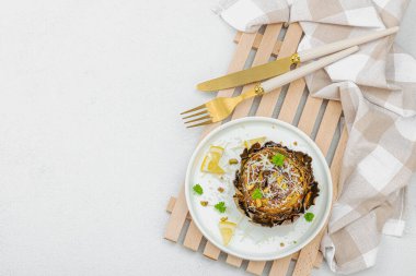 Parmesan peyniri ve şam fıstıklı enfes pişmiş enginar. Zeytinyağı, sarımsak, maydanoz ve limon. Beyaz ahşap arka plan, vejetaryen yemeği yemeye hazır, üst manzara.