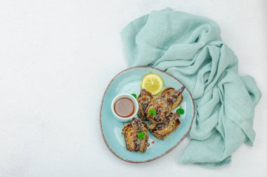 Parmesan peynirli ve soslu lezzetli bir enginar. Zeytinyağı, sarımsak, maydanoz ve limon. Hafif taş beton arka plan, vejetaryen yemeği yemeye hazır, üst manzara.
