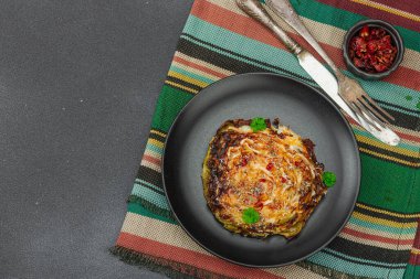 Bitki ve baharatlı ev yapımı vejetaryen biftekleri. Sağlıklı yiyecekler servis tabağında yemeye hazır, çatal bıçak takımı. Koyu taş zemin, üst görünüm