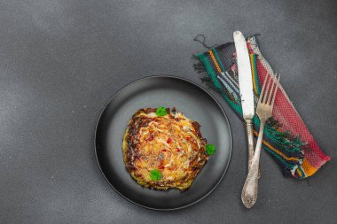 Bitki ve baharatlı ev yapımı vejetaryen biftekleri. Sağlıklı yiyecekler servis tabağında yemeye hazır, çatal bıçak takımı. Koyu taş zemin, üst görünüm