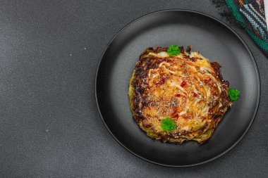 Bitki ve baharatlı ev yapımı vejetaryen biftekleri. Sağlıklı yiyecekler servis tabağında yemeye hazır, çatal bıçak takımı. Koyu taş zemin, üst görünüm