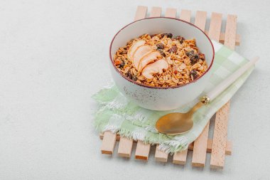Lezzetli tahıl gevreği ve kurutulmuş meyveli vejetaryen kasesi. Yemek yemeye hazır, sağlıklı kahvaltı konsepti, günaydın tarzı. Beyaz taş arkaplan, kopyalama alanı