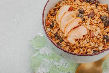 Lezzetli tahıl gevreği ve kurutulmuş meyveli vejetaryen kasesi. Yemek yemeye hazır, sağlıklı kahvaltı konsepti, günaydın tarzı. Beyaz taş beton arka plan, kapat