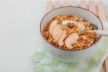 Lezzetli tahıl gevreği ve kurutulmuş meyveli vejetaryen kasesi. Yemek yemeye hazır, sağlıklı kahvaltı konsepti, günaydın tarzı. Beyaz taş arkaplan, kopyalama alanı