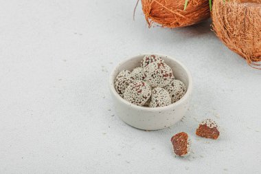 Susamlı vejetaryen hindistan cevizi şekeri. Yemek yemeye hazır, sağlıklı yaşam tarzı konsepti. Beyaz taş arkaplan, kopyalama alanı