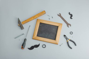 Babalar Günün kutlu olsun. El aletleri, kravat, yedek parçalar, geleneksel semboller. Tebrik kartı, düz konum, gri arkaplan, üst görünüm