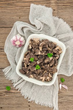 Çiğ siyah mantar ve taze maydanoz. Sağlıklı yemek pişirmek için vejetaryen malzemesi. Hobi avcısı konsepti, ahşap arka plan, üst manzara