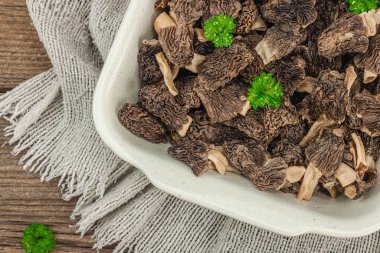 Çiğ siyah mantar ve taze maydanoz. Sağlıklı yemek pişirmek için vejetaryen malzemesi. Hobi avcısı konsepti, ahşap arka plan, üst manzara