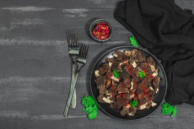 Çiğ siyah mantar ve taze maydanoz. Sağlıklı yemek pişirmek için vejetaryen malzemesi. Hobi avcısı konsepti, siyah ahşap arka plan, üst görünüm