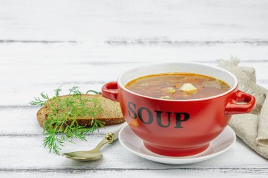 Masada sosisli, zeytinli ve sebzeli et solyanka çorbası. Geleneksel Doğu Avrupa yemeği, ekmek, çatal bıçak takımı, eski peçete. Rustik biçim, tahta tahta tahta arka plan, kopyalama alanı