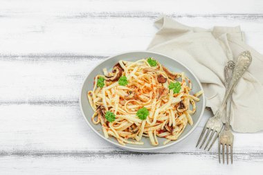 Domates soslu makarna, yenilebilir mantar, otlar ve kırmızı biber. Sağlıklı vejetaryen yemekleri yemeye hazır, porsiyon ahşap masada servis ediliyor. Rustik biçim, düz yatış, kopyalama alanı