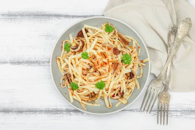 Domates soslu makarna, yenilebilir mantar, otlar ve kırmızı biber. Sağlıklı vejetaryen yemekleri yemeye hazır, porsiyon ahşap masada servis ediliyor. Kırsal stil, düz yatış, üst görünüm