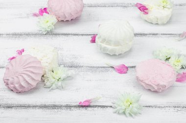 Beyaz ahşap arka planda taze çiçek yapraklı meyveli marşmelov. Laktozsuz vejetaryen tatlı, sağlıklı yaşam tarzı, düz yatış, yakın çekim.