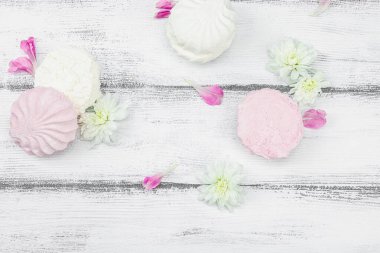 Beyaz ahşap arka planda taze çiçek yapraklı meyveli marşmelov. Laktozsuz vejetaryen tatlı, sağlıklı yaşam tarzı, düz yatış, üst görünüm