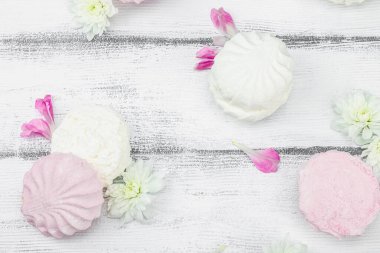 Beyaz ahşap arka planda taze çiçek yapraklı meyveli marşmelov. Laktozsuz vejetaryen tatlı, sağlıklı yaşam tarzı, düz yatış, üst görünüm