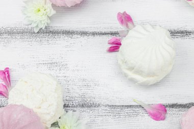 Beyaz ahşap arka planda taze çiçek yapraklı meyveli marşmelov. Laktozsuz vejetaryen tatlı, sağlıklı yaşam tarzı, düz yatış, üst görünüm