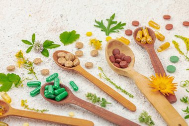 Bitki bazlı takviyeler, taze otlar ve çiçeklerle birlikte doğal vitaminler. Organik maddeler, bütünsel sağlık kavramlarını, alternatif yaşam tarzını öneriyor. Işık taşı arkaplanı, kapat