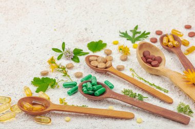 Bitki bazlı takviyeler, taze otlar ve çiçeklerle birlikte doğal vitaminler. Organik maddeler, bütünsel sağlık kavramlarını, alternatif yaşam tarzını öneriyor. Işık taşı arkaplanı, boşluğu kopyala