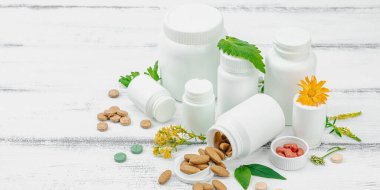 Bitki bazlı takviyeler, taze otlar ve çiçeklerle birlikte doğal vitaminler. Organik maddeler, bütünsel sağlık kavramlarını, alternatif yaşam tarzını öneriyor. Beyaz arkaplan, pankart biçimi