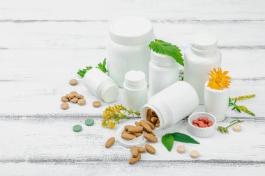 Bitki bazlı takviyeler, taze otlar ve çiçeklerle birlikte doğal vitaminler. Organik maddeler, bütünsel sağlık kavramlarını, alternatif yaşam tarzını öneriyor. Beyaz arkaplan, alanı kopyala