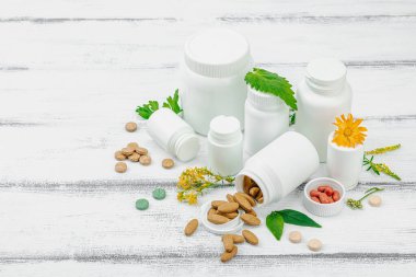 Bitki bazlı takviyeler, taze otlar ve çiçeklerle birlikte doğal vitaminler. Organik maddeler, bütünsel sağlık kavramlarını, alternatif yaşam tarzını öneriyor. Beyaz arkaplan, alanı kopyala