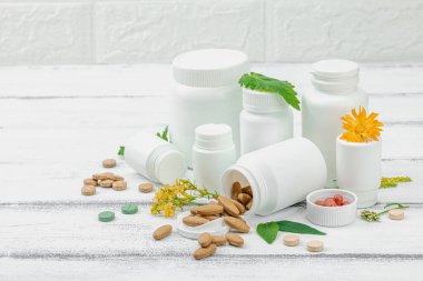 Bitki bazlı takviyeler, taze otlar ve çiçeklerle birlikte doğal vitaminler. Organik maddeler, bütünsel sağlık kavramlarını, alternatif yaşam tarzını öneriyor. Beyaz arkaplan, alanı kopyala