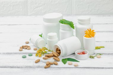 Bitki bazlı takviyeler, taze otlar ve çiçeklerle birlikte doğal vitaminler. Organik maddeler, bütünsel sağlık kavramlarını, alternatif yaşam tarzını öneriyor. Beyaz arkaplan, kapat