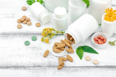 Bitki bazlı takviyeler, taze otlar ve çiçeklerle birlikte doğal vitaminler. Organik maddeler, bütünsel sağlık kavramlarını, alternatif yaşam tarzını öneriyor. Beyaz arkaplan, kapat