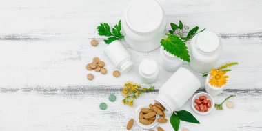Bitki bazlı takviyeler, taze otlar ve çiçeklerle birlikte doğal vitaminler. Organik maddeler, bütünsel sağlık kavramlarını, alternatif yaşam tarzını öneriyor. Beyaz arkaplan, pankart biçimi
