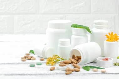 Bitki bazlı takviyeler, taze otlar ve çiçeklerle birlikte doğal vitaminler. Organik maddeler, bütünsel sağlık kavramlarını, alternatif yaşam tarzını öneriyor. Beyaz arkaplan, alanı kopyala